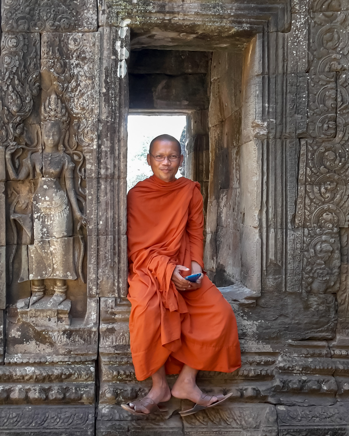 A photograph of a buddhist monk at the Bayon Temple © Regan Thacker. One of the top ten places ranked in the Ultimate Travel List by the Lonely Planet